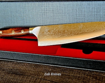 May include: A black box with a red interior and a silver and wood handled knife with a patterned blade. The box has the text "Zab Knives" on the bottom.