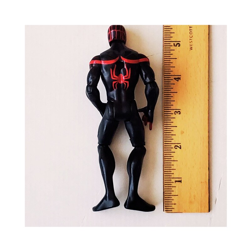 May include: Black action figure of a superhero with red accents and a spider design on the back. The figure is approximately 5 inches tall.