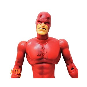 Puede incluir: Figura de acci&oacute;n roja de un superh&eacute;roe con expresi&oacute;n severa. La figura tiene un traje rojo con un logotipo "D" negro en el pecho y peque&ntilde;os cuernos en la cabeza. La figura posa con los brazos ligeramente extendidos.