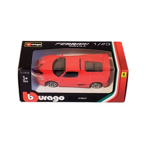 May include: A red 1/43 scale Burago Ferrari F50 die-cast toy car in its original packaging. The box features the Ferrari logo and the words "Ferrari Race & Play".