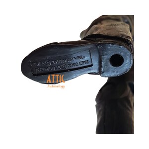 May include: Close-up of a black action figure's foot, with the text "TM & &copy; 2002 MARVEL: THE MOVIE &copy; 2002 CPII" imprinted on the sole. The word "ATTIC" and "Archaeology" are also visible.