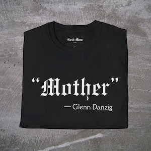 May include: Black t-shirt with white text that reads "Mother" - Glenn Danzig.