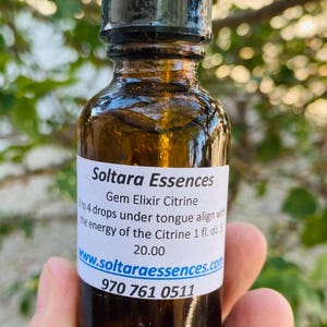 May include: A brown glass bottle of Soltara Essences Gem Elixir Citrine. The label reads "3 to 4 drops under tongue align with the energy of the Citrine 1 fl. oz." and includes a website and phone number.