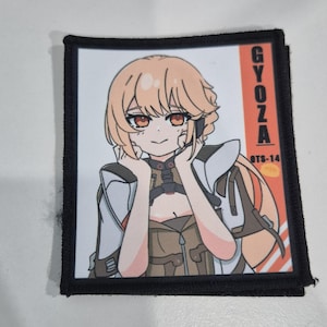 May include: Square patch with a cartoon illustration of a female anime character with blonde hair and red eyes. The patch has the word "GYOZA" in orange and the text "BTS-14" in white.