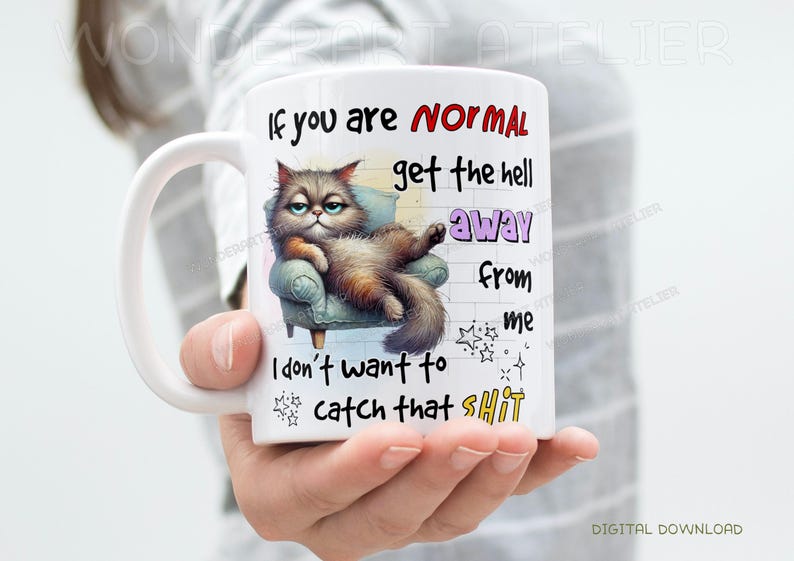 May include: White ceramic mug featuring a grumpy cat illustration lounging on a small armchair. The mug has text that reads "If you are NORMAL get the hell away from me. I don't want to catch that SHIT."