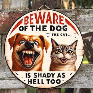 May include: Round wooden sign with a distressed look, featuring a cartoon dog and cat with menacing expressions. The sign reads "BEWARE OF THE DOG... THE CAT... IS SHADY AS HELL TOO." The sign is 12 x 12 inches.