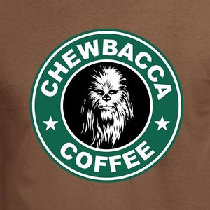 May include: A brown t-shirt with a green circle logo that says "Chewbacca Coffee" with a white star on each side. The logo features a black and white image of Chewbacca from Star Wars.