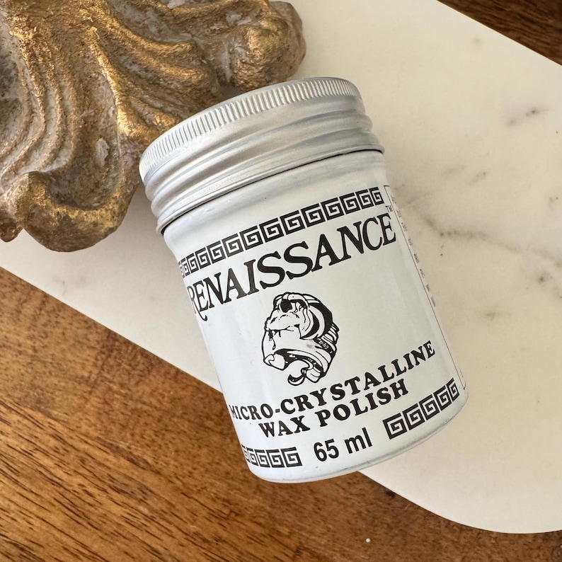 May include: A small, white jar of Renaissance Micro-Crystalline Wax Polish with a silver lid. The label features the word "RENAISSANCE" and a bulldog graphic. The jar contains 65 ml of wax polish.