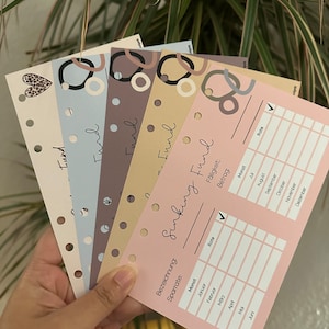 May include: A pink printable planner page with the title "Sinking Fund" and a table to track monthly savings. The table includes columns for month, rate, and amount. The page is designed with a minimalist aesthetic and features a checkmark in the rate column.