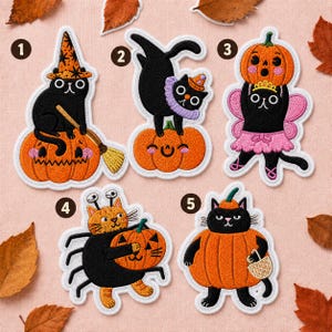May include: Five embroidered patches featuring black and orange cats in Halloween costumes. Designs include a cat with a witch hat on a pumpkin, a cat on a pumpkin, a cat in a fairy outfit, a cat spider, and a cat wearing a pumpkin costume.