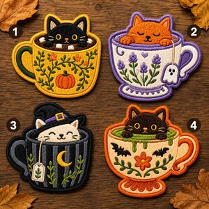May include: Four embroidered patches featuring cats in teacups. Patch 1: black cat in a yellow pumpkin mug. Patch 2: orange cat in a lavender floral teacup with a ghost tea bag. Patch 3: white cat in a striped mug with a moon. Patch 4: black cat in a floral mug.