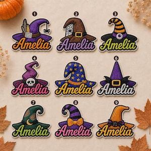 May include: Nine embroidered patches featuring various witch hat designs, each paired with the name Amelia in cursive script. The hats include patterns like stars, stripes, spiderwebs, and skulls in colors including purple, orange, brown, and green.