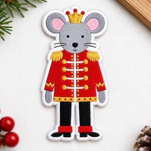 May include: An embroidered patch featuring a gray mouse wearing a gold crown and a red soldier uniform with gold buttons, gold epaulets, and black trousers. The mouse has pink inner ears, black whiskers, and a black nose, all outlined in white.