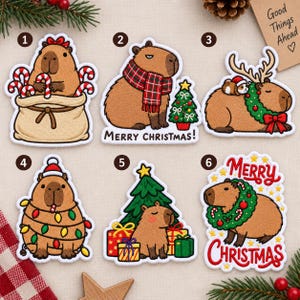 May include: Six embroidered patches featuring capybaras in Christmas themes. Patch 1: capybara in a sack with candy canes. Patch 2: capybara with a plaid scarf and tree. Patch 3: capybara with antlers and a wreath. Patch 4: capybara wrapped in lights.
