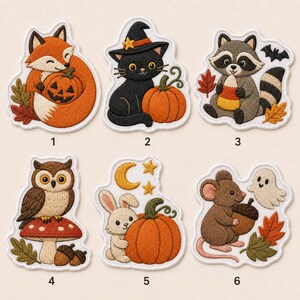 May include: Six embroidered patches featuring autumn themes: a fox with a jack-o'-lantern, a black cat in a witch hat with a pumpkin, a raccoon with candy corn, an owl on a mushroom, a rabbit with a pumpkin, and a mouse with an acorn and ghost.