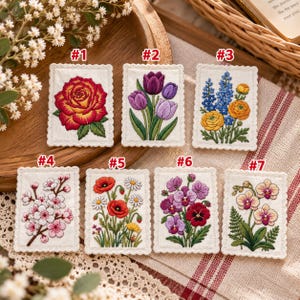 May include: Seven rectangular fabric patches with scalloped edges, each featuring detailed embroidery of different flowers: a red rose, purple tulips, blue and yellow ranunculus, cherry blossoms, poppies, pansies, and orchids, labeled #1 through #7.