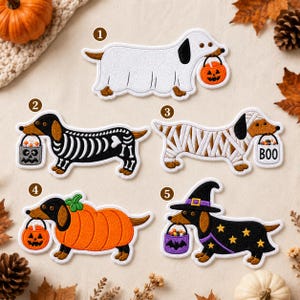 May include: Five embroidered dachshund patches numbered one through five. The designs feature a ghost, a skeleton, a mummy with a BOO bucket, a pumpkin, and a witch with a star-patterned cape, all carrying small Halloween treat buckets.