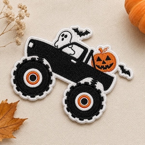 May include: An embroidered patch featuring a black monster truck with large tires, a white ghost sitting in the driver seat, and an orange jack-o'-lantern pumpkin in the back. Two small black bats are embroidered above and behind the truck.