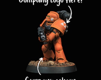 May include: A miniature orange space marine with a black gun and a white company logo on the shoulder pad. The base is painted brown with a white company logo.