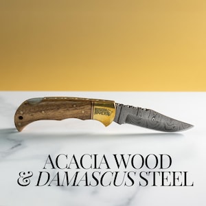 May include: A folding pocket knife with a Damascus steel blade and an acacia wood handle. The handle has a brass inlay with the words "Bison River" and a bear logo.