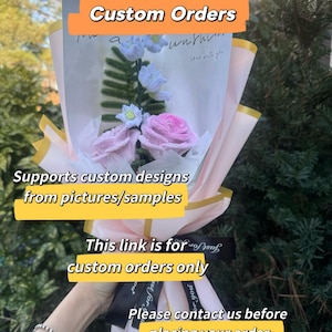 Op de afbeelding: Een boeket van roze en witte bloemen verpakt in roze en wit papier met gouden rand. Het boeket is vastgebonden met een zwart lint. Tekst op de afbeelding luidt "Reserved Listing for Custom Orders", "Supports custom designs from pictures/samples" en "This link is for custom orders only".