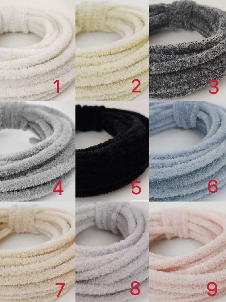May include: Nine spools of fuzzy yarn in various colours, including white, cream, grey, black, light blue, beige, light grey, and pink. Each spool is labelled with a number from 1 to 9.