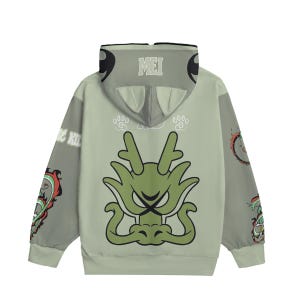 Puede incluir: Una sudadera con capucha verde salvia con un gran diseño de dragón verde en la espalda. La capucha muestra la palabra "MEI" y orejas estilizadas. Diseños con temática de dragón adornan las mangas. Es una prenda casual.