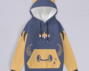 May include: A blue hoodie with yellow accents and a cat ear hood. The hoodie features a graphic of a crown, a mask, and a crescent moon. The pocket on the front of the hoodie has a stylized face with two crescent moons for eyes.