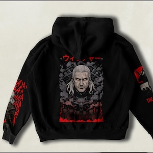 May include: Black hooded sweatshirt with a graphic print of a man with white hair and a beard. The graphic is surrounded by red smoke and the text "ウィッチャー" in Japanese. The sleeves have red text that says "HA HA HA" repeated.