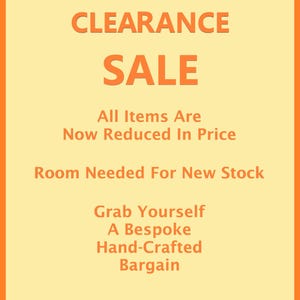 May include: A rectangular sign with a light yellow background and an orange border. The text reads: CLEARANCE SALE, All Items Are Now Reduced In Price, Room Needed For New Stock, Grab Yourself A Bespoke Hand-Crafted Bargain in orange font.