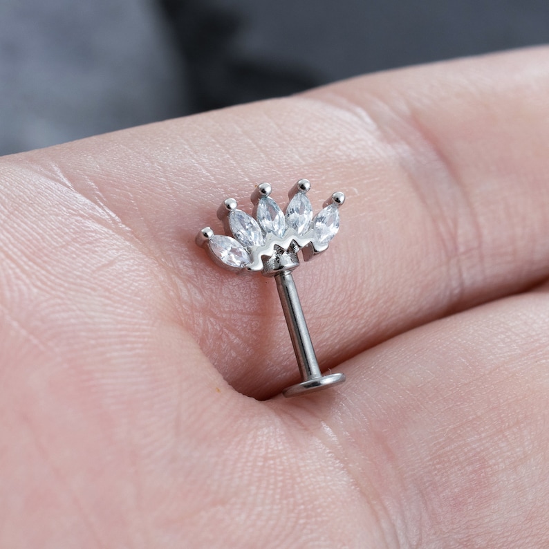 May include: Silver body jewellery with a clear crystal crown top.
