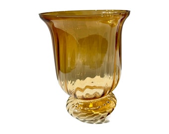 May include: A clear amber glass vase with a wide, rounded base and a flared, tulip-shaped top.