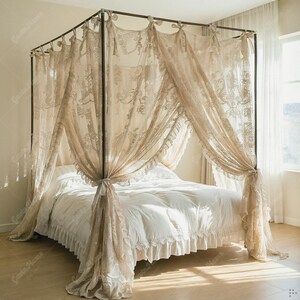 May include: A four-poster bed with a metal frame and draped with sheer, beige lace curtains. The bed is made with white bedding, including a ruffled bed skirt. The curtains are tied back at the posts.