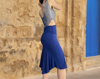 May include: A woman wearing a silver sequined top with a cut-out detail and a royal blue skirt with a ruffled hem.
