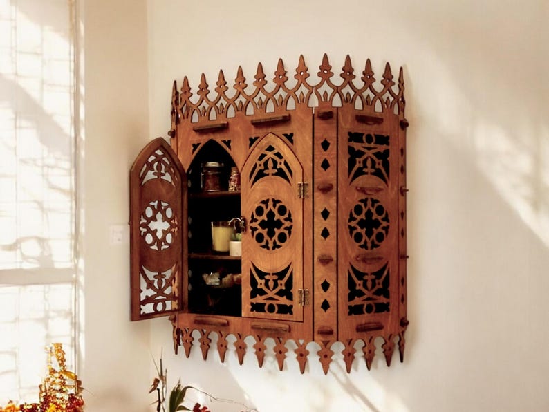 Peut inclure: Une armoire en bois avec un design gothique. L'armoire a une forme d'arche pointue et des sculptures complexes. Les portes sont ouvertes, r&eacute;v&eacute;lant des &eacute;tag&egrave;res &agrave; l'int&eacute;rieur.