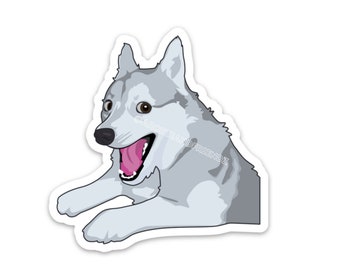 May include: A die-cut sticker featuring a stylized illustration of a grey and white husky dog with its mouth open in a wide, happy expression. The dog is shown from the chest up, lying down with its front paws extended. The text ARCHIEANDFRIENDZ is visible.