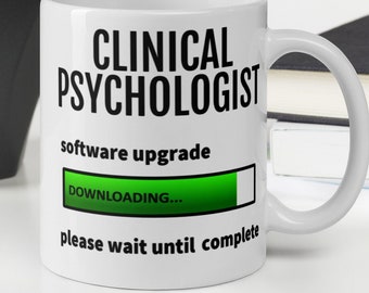 May include: White ceramic mug with black text that reads "Clinical Psychologist software upgrade" and a green progress bar that says "Downloading..." below it. The text "please wait until complete" is below the progress bar.