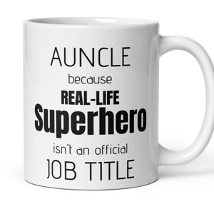 Può includere: Tazza in ceramica bianca con la scritta nera "AUNCLE because REAL-LIFE Superhero isn't an official JOB TITLE". La tazza ha un manico curvo ed è progettata per bevande calde.