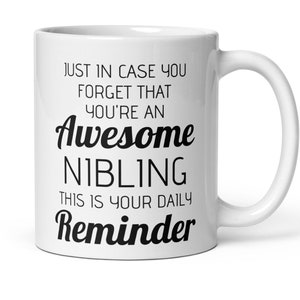 Può includere: Una tazza da caffè in ceramica bianca con testo nero che recita "Just in case you forget that you're an Awesome Nibling This is your daily Reminder".