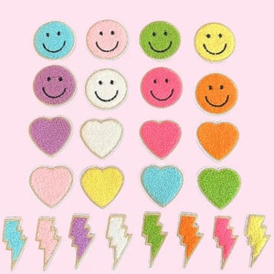 May include: A set of 20 colorful iron-on patches featuring smiley faces, hearts, and lightning bolts. The patches are made of fuzzy fabric and come in a variety of colors, including pink, blue, green, yellow, orange, and purple.