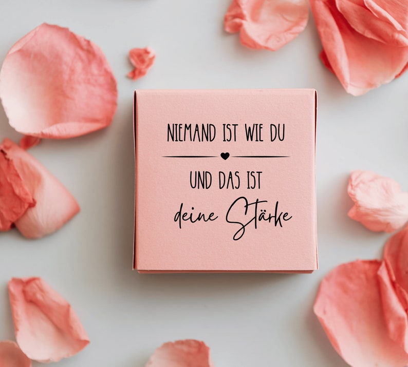 K&ouml;nnte beinhalten: Eine rosa Box mit dem Text "Niemand ist wie du und das ist deine St&auml;rke" (Niemand ist wie du und das ist deine St&auml;rke) in schwarzer Schrift.