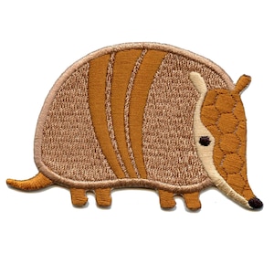 May include: Embroidered patch of a brown armadillo with a textured shell. The armadillo is facing right and has a small, black nose.