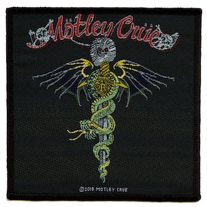 May include: A black and green embroidered patch with the text "Motley Crue" in red and white. The patch features a snake wrapped around a sword with wings.