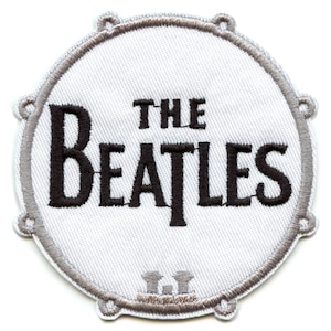 May include: White embroidered patch with a black and white image of a drum with the text "THE BEATLES" on it.