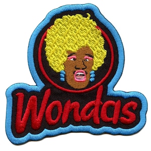 Könnte beinhalten: Ein gestickter Aufnäher in Rot und Blau mit dem Wort "Wondas" in roten Buchstaben. Der Aufnäher zeigt ein Cartoon-Bild einer Person mit gelbem Haar, brauner Haut und einem rosa Mund.