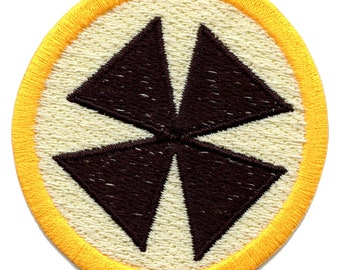 May include: A brown embroidered patch with a four-pointed star design, surrounded by a yellow border.
