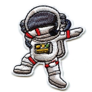 May include: Embroidered iron-on patch of a white astronaut in a space suit with a red stripe on the helmet, a yellow and green patch on the chest, and red stripes on the legs. The astronaut is in a dancing pose with one leg raised.