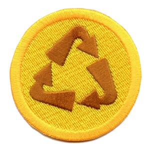 Könnte beinhalten: Ein gelber runder Patch mit einem braunen gestickten Recycling-Symbol.