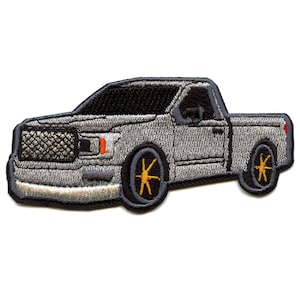 May include: A gray embroidered patch of a pickup truck with black wheels and orange rims.