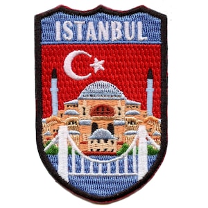 May include: Embroidered patch with a red background and a white crescent moon and star. The patch features a depiction of the Hagia Sophia mosque in Istanbul, Turkey. The text "ISTANBUL" is written in white at the top of the patch.